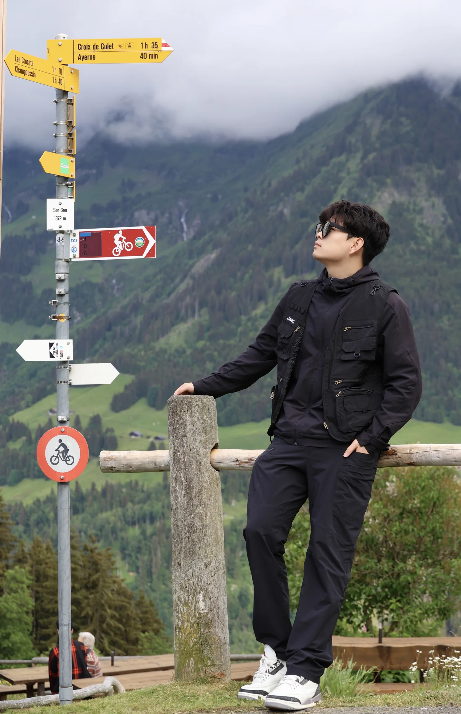 LI Yinlong beside mountain trail signs